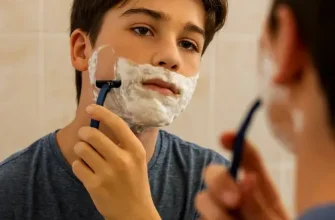 Подросток бреется перед зеркалом — этап полового созревания. Статья о первых поллюциях у мальчиков, гормональных изменениях и том, как родителям помочь подростку принять естественные процессы взросления.